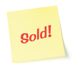 Sticky note indicating item is sold, isolated on white